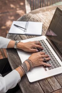 personne tapant sur un MacBook Pro sur une table en bois marron pendant la journée photo